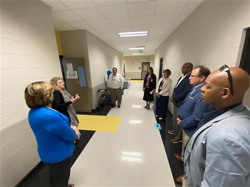 Board members and Dr. Nichols getting briefing outside of a special education classroom at James Clemens High School